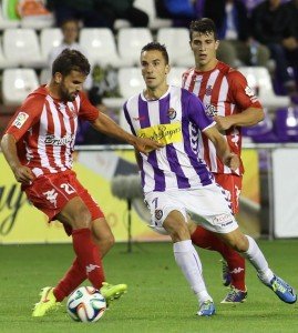 Óscar Díaz da un pase entre dos rivales || Foto: Real Valladolid
