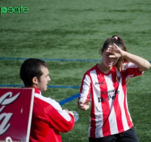 Miguel Lauría da una botella de agua a una de sus jugadoras